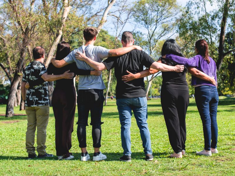 Rear view of a group of hugging friends. Friendship and support concept.